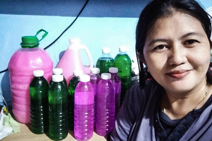 Ruby with the dishwashing liquid she sells to earn additional income for her family.